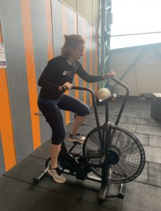 Elaine on assault bike in cardio tabata workout